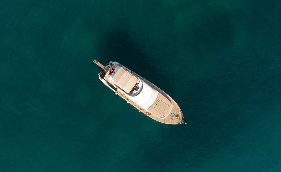 Imagem aérea de barco visto por cima no mar.